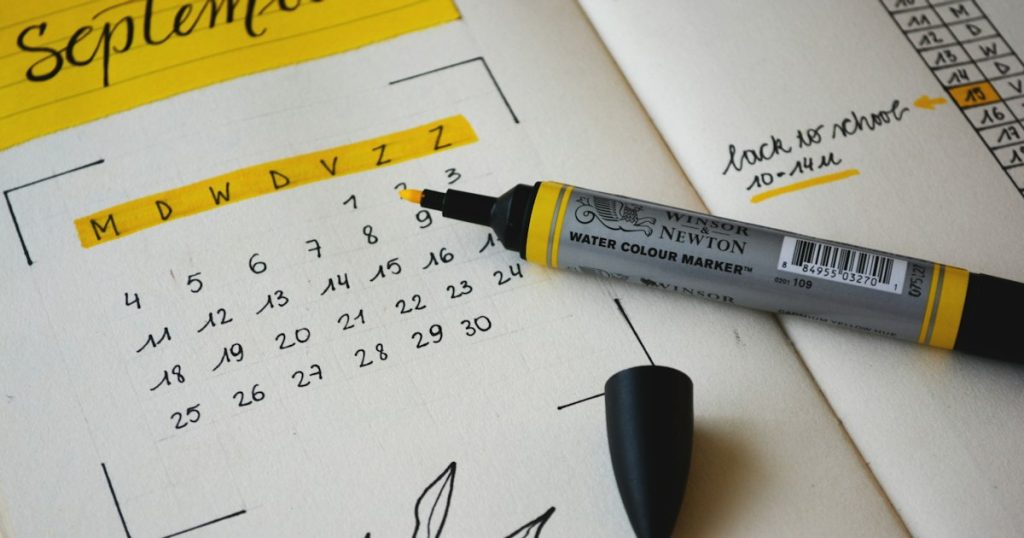 Notebook and pen used for scheduling on a desk