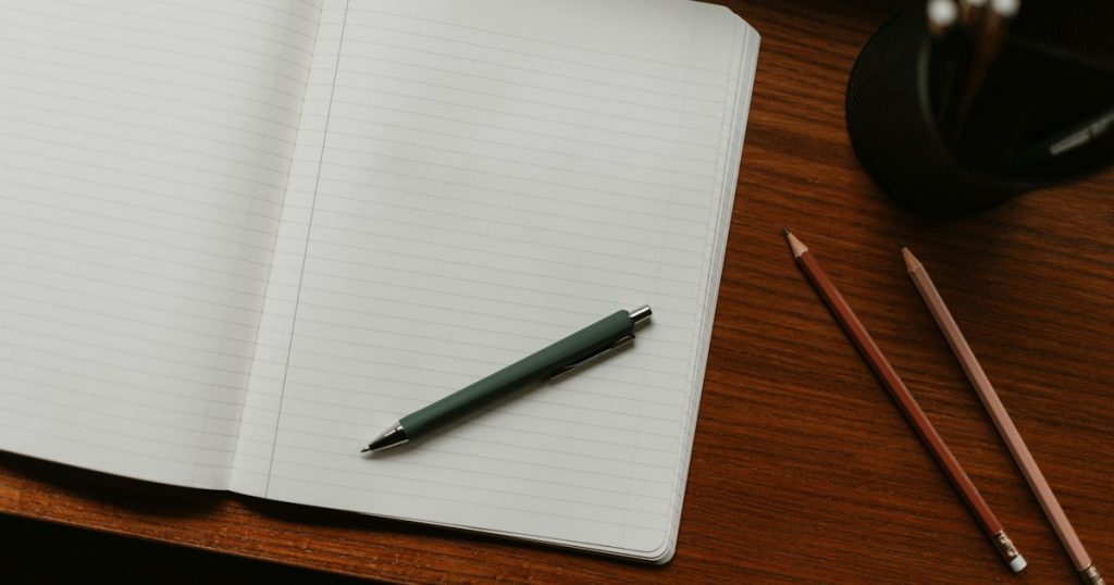 Open notebook with a pen on a desk for writing outreach copy