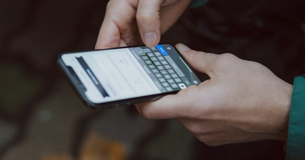Hand holding a smartphone with a message notification
