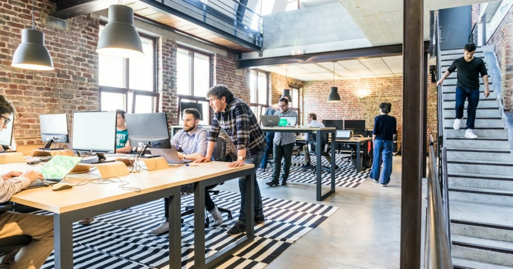 Colleagues collaborating on laptops in a modern office