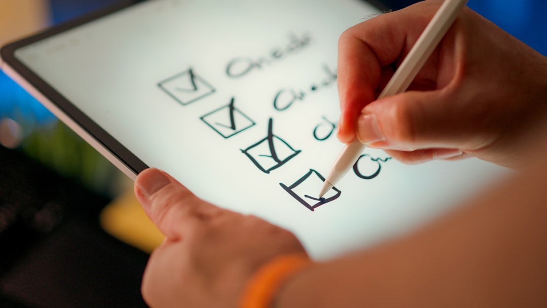 Hand ticking boxes on a compliance checklist notepad