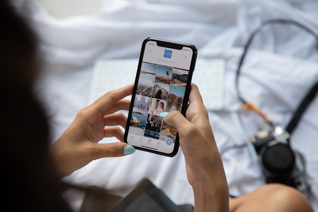 Hand holding a smartphone scrolling through a social media feed