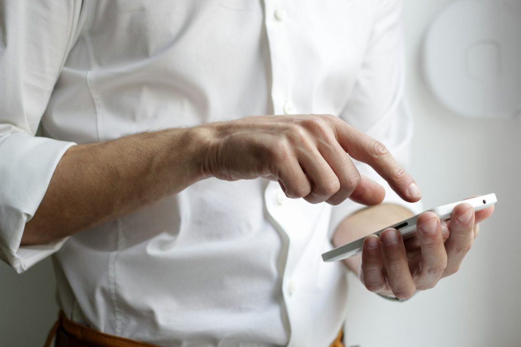 Hand holding a smartphone to check a LinkedIn notification for a buying signal