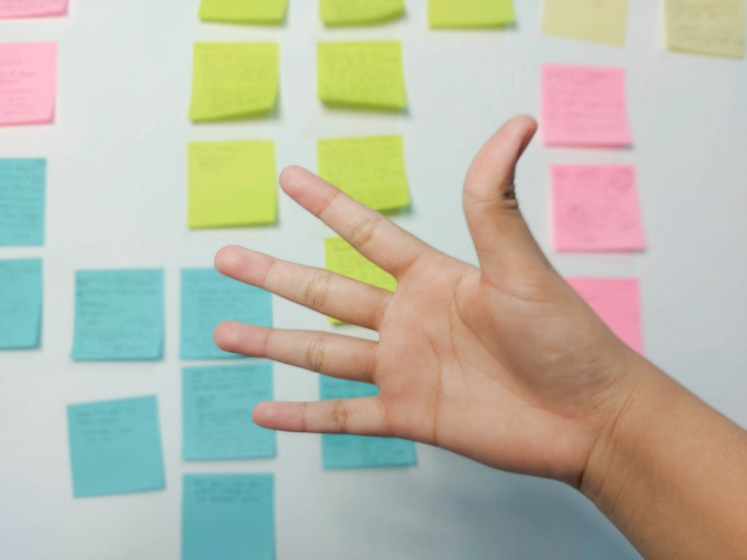 Hand holding yellow sticky notes representing stakeholders mapped out for a B2B buying committee