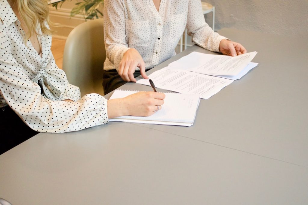 Two people reviewing a printed client report together at a desk