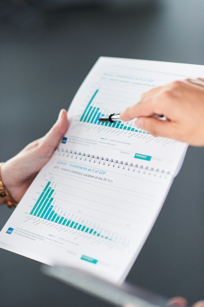 Two colleagues pointing at bar charts on a printed report while discussing results