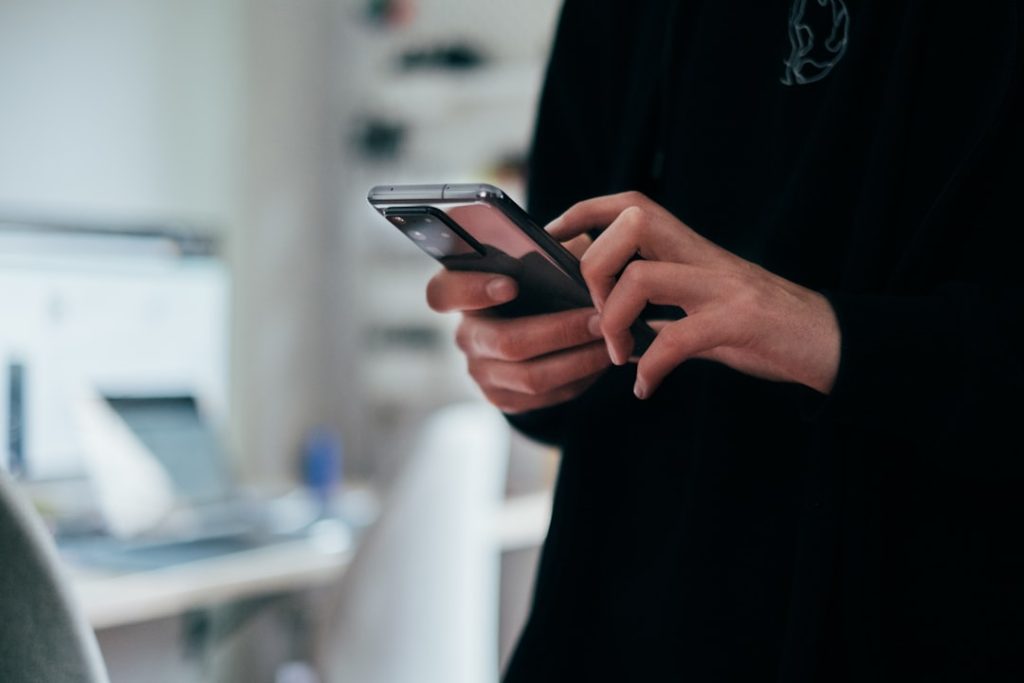 Hand holding a smartphone showing a message notification, representing fast reply speed to a LinkedIn lead