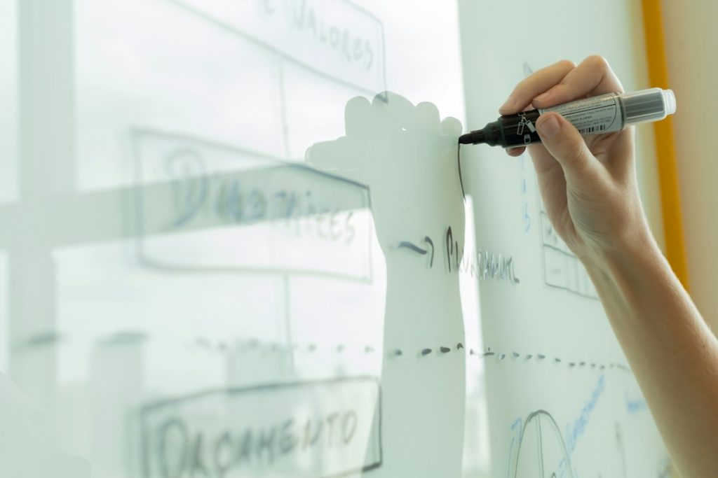 Hand drawing a stakeholder map and connecting lines on a whiteboard during LinkedIn outreach planning