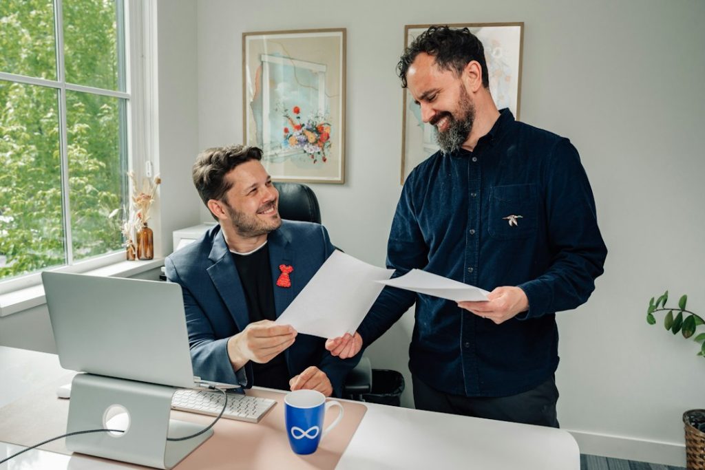 Two colleagues reviewing an account plan document together at a desk in a bright office