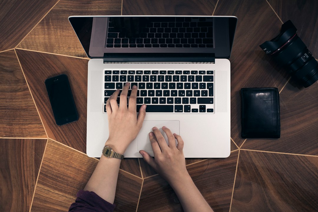 Close-up of hands typing on a laptop keyboard, representing human-reviewed LinkedIn outreach messaging