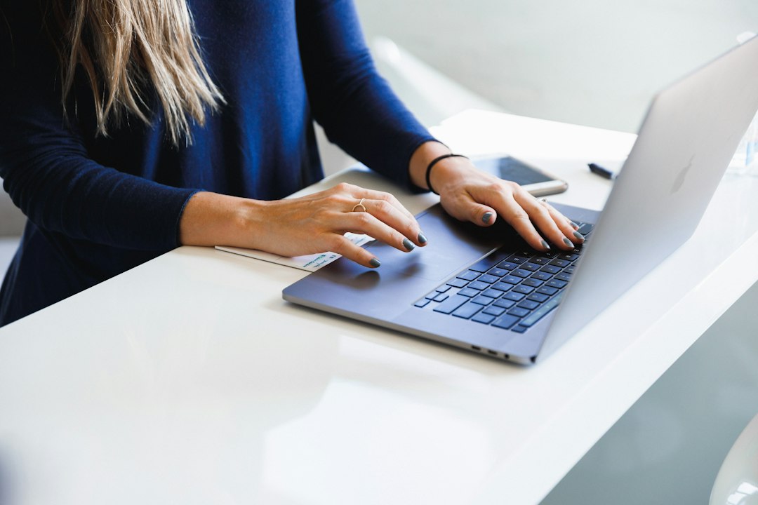 Close-up of hands typing on a laptop keyboard, reviewing LinkedIn connection requests