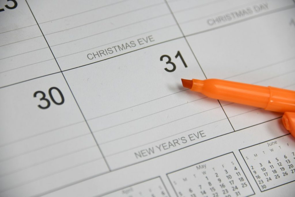 Hand marking a date on a desk calendar to plan Q4 LinkedIn outreach